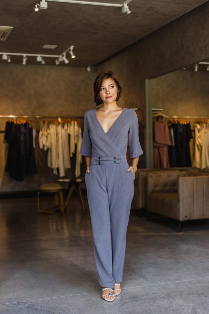 Full-length shot of a woman wearing a sophisticated monochromatic outfit in charcoal gray, creating a seamless vertical line that elongates the silhouette.