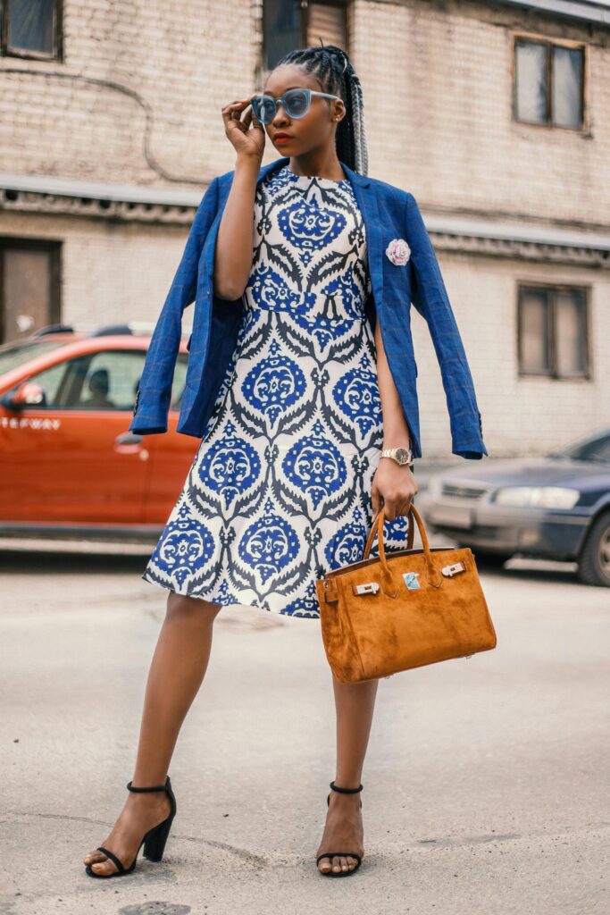 Mujer usando un vestido de corte imperio y una chaqueta abierta, mostrando un truco visual para disimular la barriguita con elegancia.