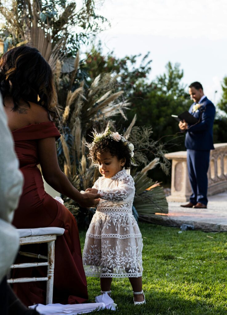 Convidada vestidos de forma elegante conversando em uma criança no casamento, demonstrando comportamento social adequado.
