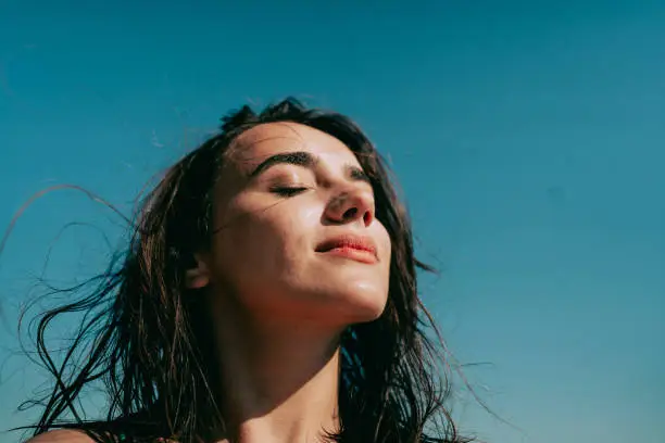 foto de uma mulher aproveitando o sol em sua plenitude.