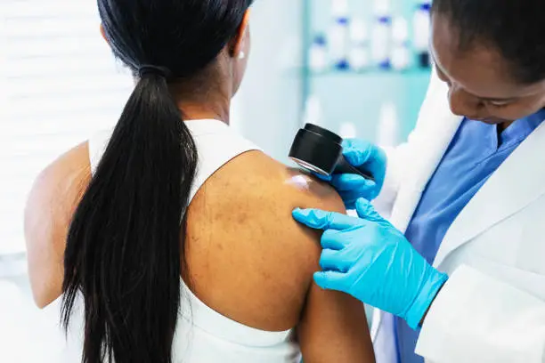 imagem mostra dermatologista verificando pele.